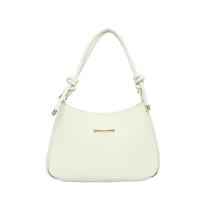 An off-white shoulder bag with a curved top, knotted strap details, and a small gold bar accent on the front, shown against a plain white background.