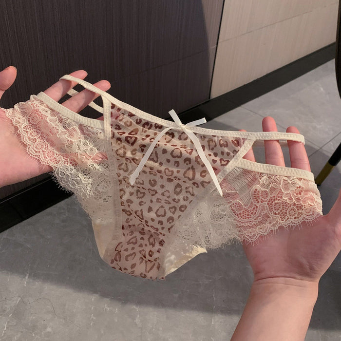 A pair of women's lace underwear held up by two hands. The underwear features a brown leopard print pattern over a sheer nude-beige mesh base, with a small white bow at the center front and beige lace trim.