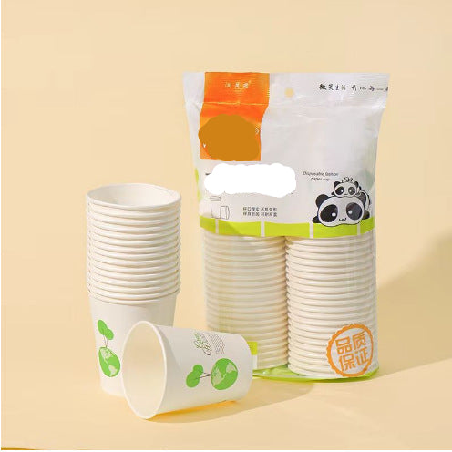 A package of disposable paper cups with several stacks of white cups printed with green leaf graphics, displayed on a warm beige background.