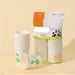 A package of disposable paper cups with several stacks of white cups printed with green leaf graphics, displayed on a warm beige background.