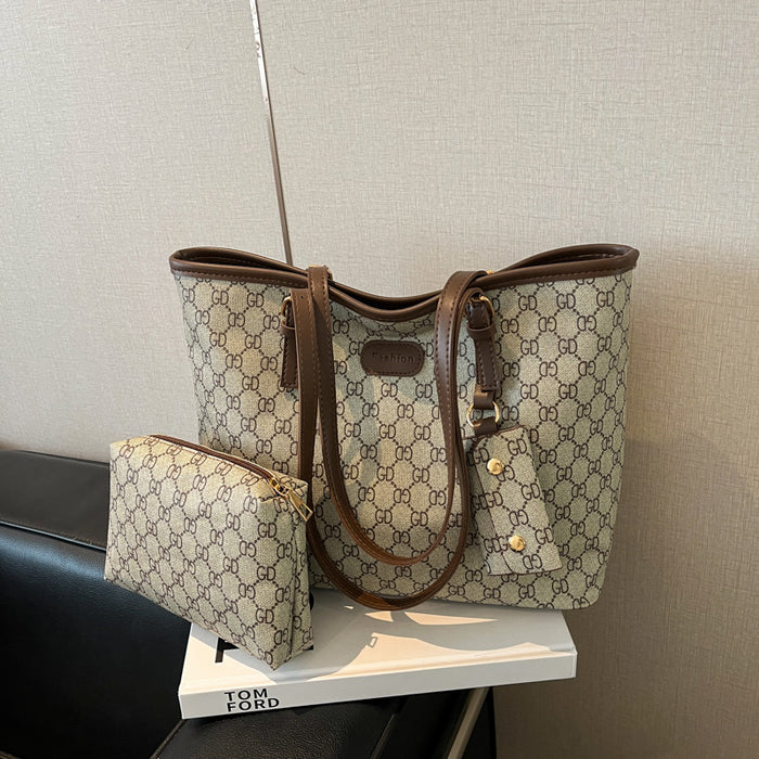 A beige and brown GG Supreme tote bag with matching zip pouch, displayed on a white book on a black leather chair against a textured beige wall.
