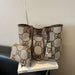 A beige tote bag with a brown monogram pattern and matching zip pouch, displayed on a white book on a black chair against a textured beige wall.