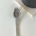 Silver watch with a metallic band on a light surface