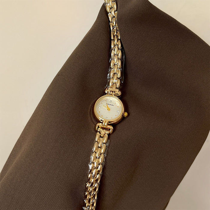 Gold chain watch on a brown fabric background