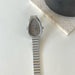 Silver watch with a metallic band on a light surface