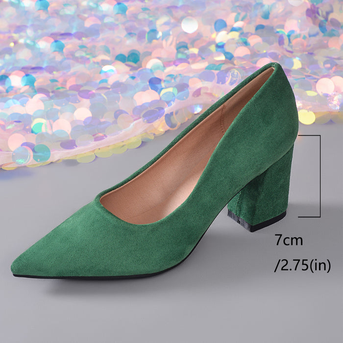 A green suede pointed-toe pump with a block heel, shown on a gray surface with a sparkling multicolor sequin backdrop. A measurement overlay indicates the heel height as 7cm (2.