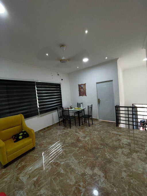 Living room with yellow sofa, dining table, and marble floor