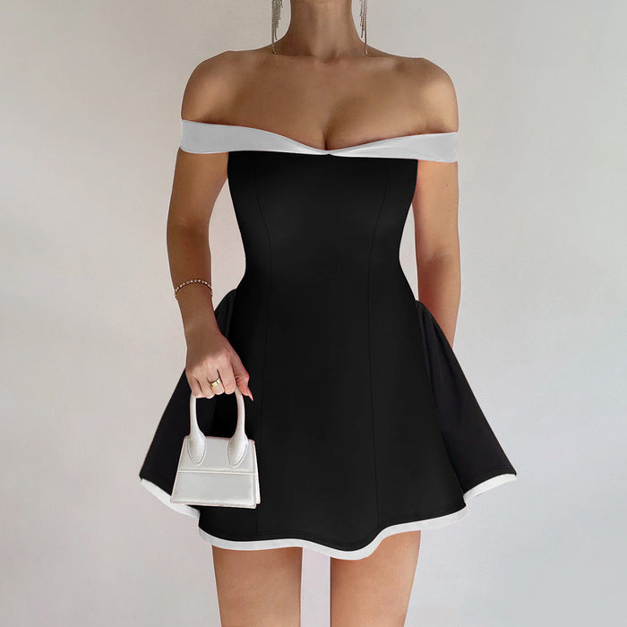 Black and white dress with a white handbag on a plain background
