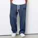 Person wearing blue textured sweatpants with a white label on a white background