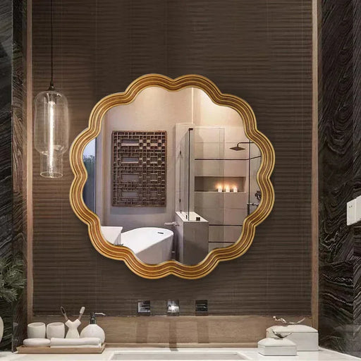 Decorative gold-framed mirror in a modern bathroom setting