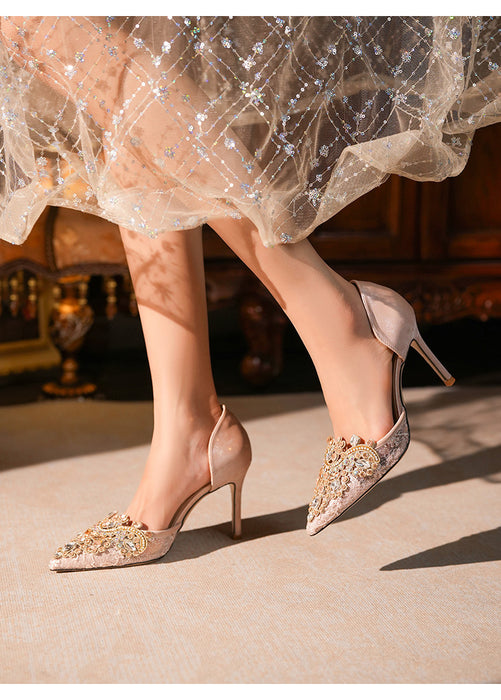 Elegant high-heeled shoes with decorative elements worn with a sparkling dress.