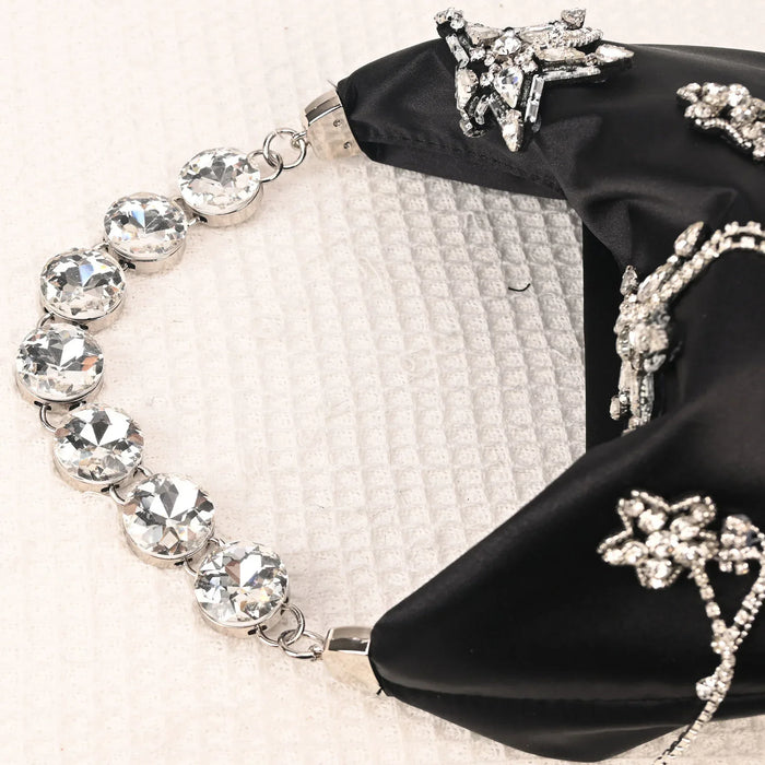 Bracelet with star-shaped crystal embellishments on a black satin bag.