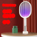 Electric fly swatter with purple light on a wooden surface against a red curtain background