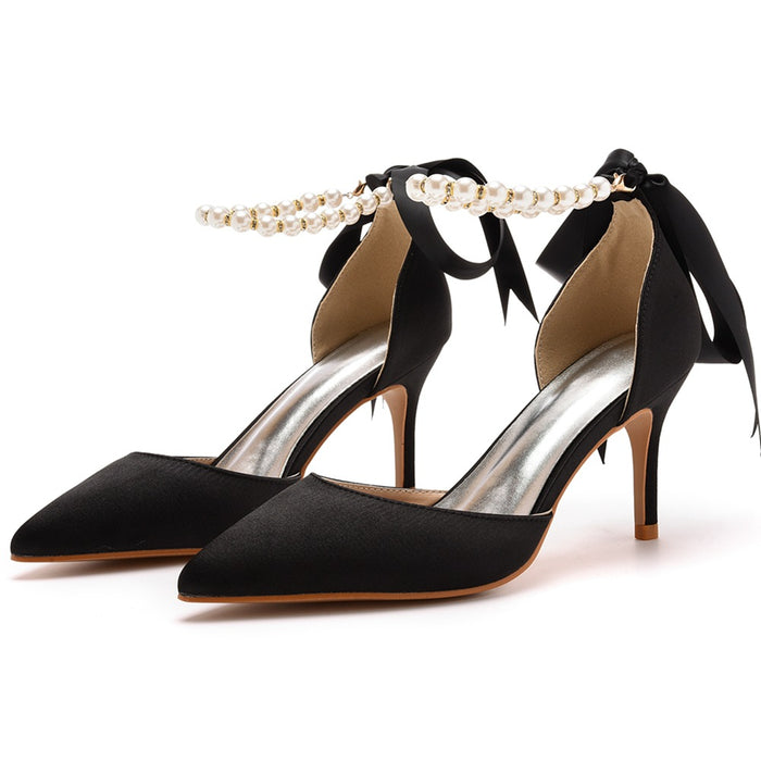 Black high-heeled shoes with bow and pearl detail on a white background