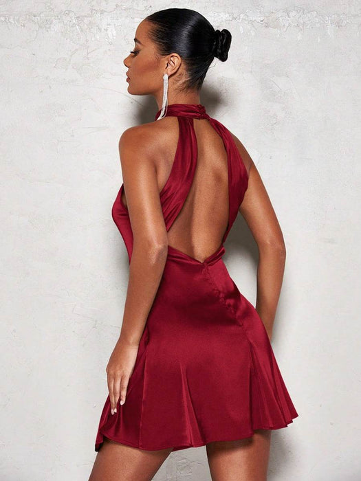 Woman wearing a red dress with a backless design against a light background