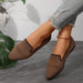 Brown mesh shoes worn with rolled-up jeans on a neutral background