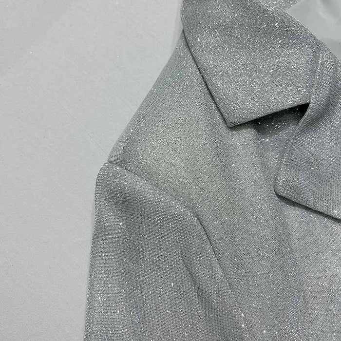 Close-up of a textured gray fabric with a collar on a light gray background