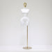 White mannequin torso on a gold stand against a white background