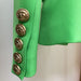 Green jacket with gold buttons on a neutral background