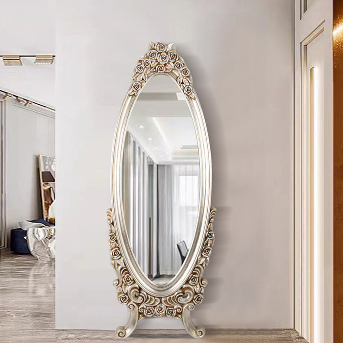 Decorative oval mirror with ornate frame on a wall