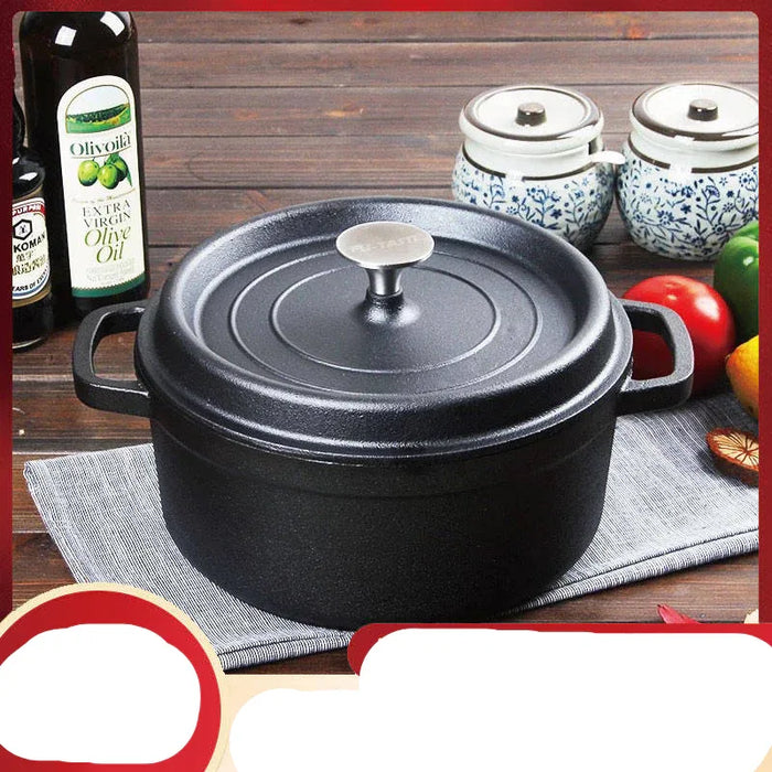Black pot with a lid on a wooden table with olive oil bottles and vegetables.
