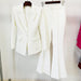 White suit jacket and pants hanging on a rack against a white background