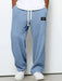 Blue textured sweatpants with a white label on a plain background