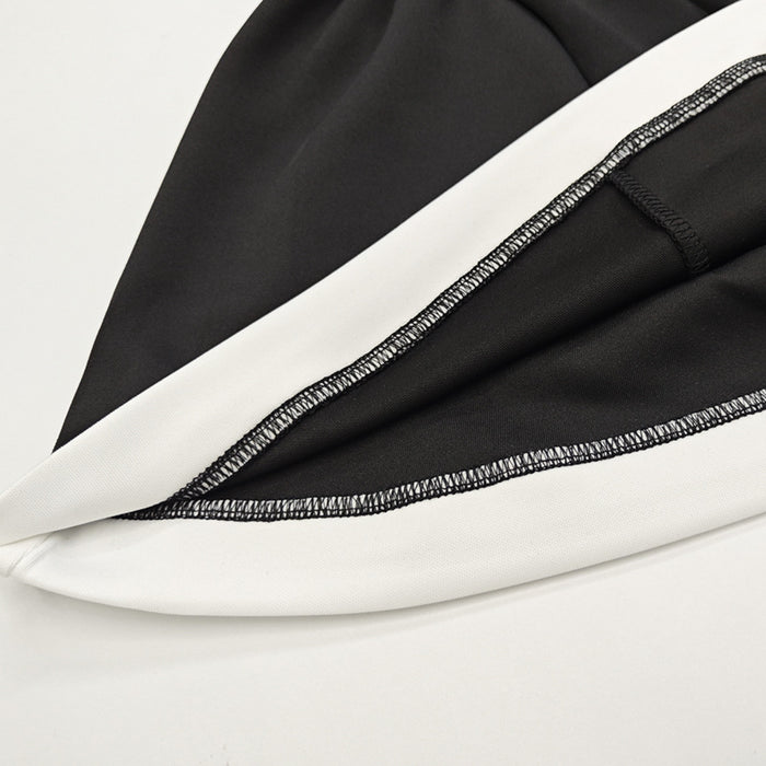 Close-up of black and white fabric with a visible seam on a light gray background