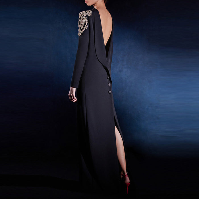 Black evening gown with gold embellishments on a dark blue background