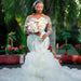 Bride in a white wedding dress holding a bouquet with a garden background