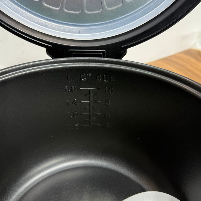 Black waffle maker with open lid on a wooden surface