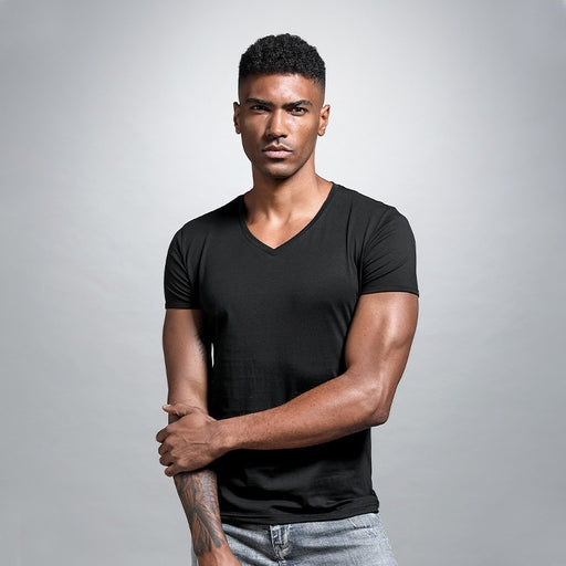 Man wearing a black t-shirt against a gray background