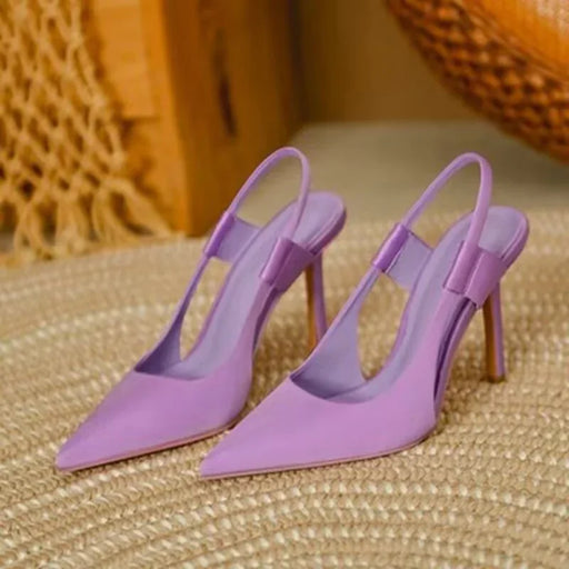 Pair of purple high-heeled shoes on a textured surface with a woven background.