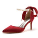 Red high-heeled shoe with pearl anklet on a white background