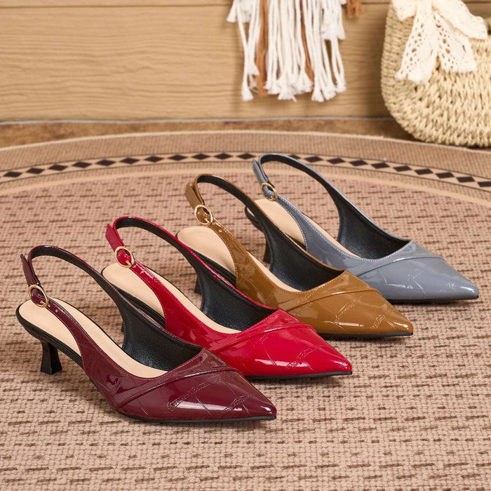 Four pointed slingback pumps arranged on a woven rug, showing glossy patent leather finishes in burgundy, red, tan, and slate blue-gray. The shoes have kitten heels and gold-tone slingback hardware.