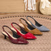 Four pointed slingback pumps arranged on a woven rug, showing glossy patent leather finishes in burgundy, red, tan, and slate blue-gray. The shoes have kitten heels and gold-tone slingback hardware.