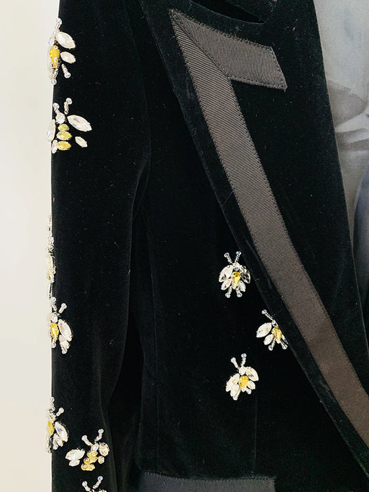 Black velvet garment with floral embroidery on a white background