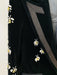 Black velvet garment with floral embroidery on a white background