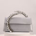 Gray handbag with a decorative chain handle on a light gray background