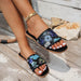 Black sandals with floral sequins worn on a wooden floor