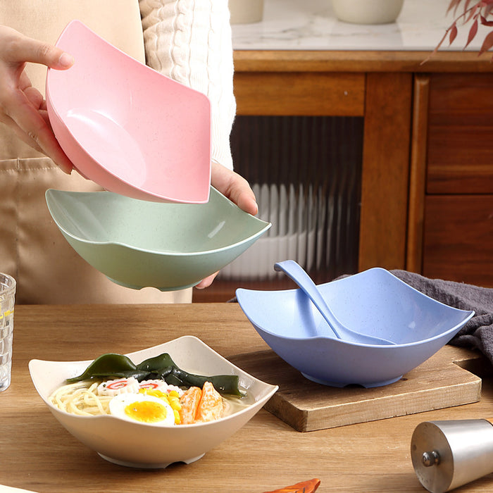 Person holding two colorful bowls with a third bowl on a table containing food.