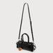 Black handbag with a strap on a light gray background