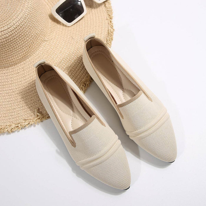 Pair of beige mesh shoes with a straw hat on a light background