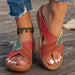 Red sandals with green accents worn on a wooden surface