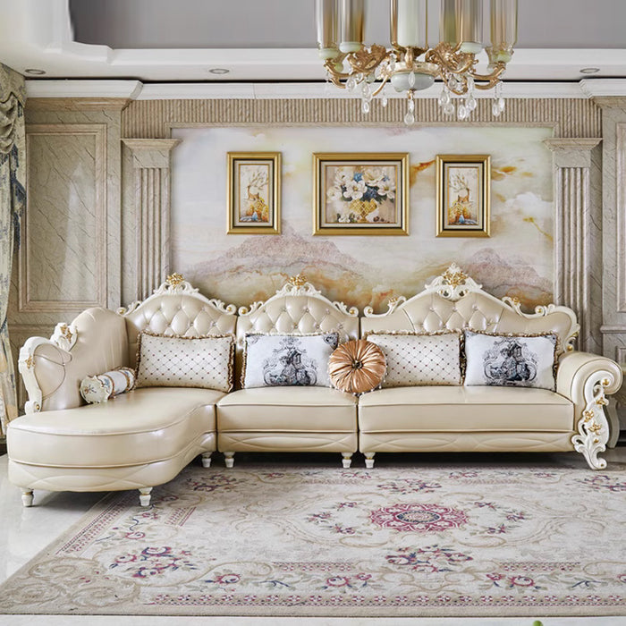 Luxurious living room with an ornate beige sofa, decorative pillows, and framed artwork.
