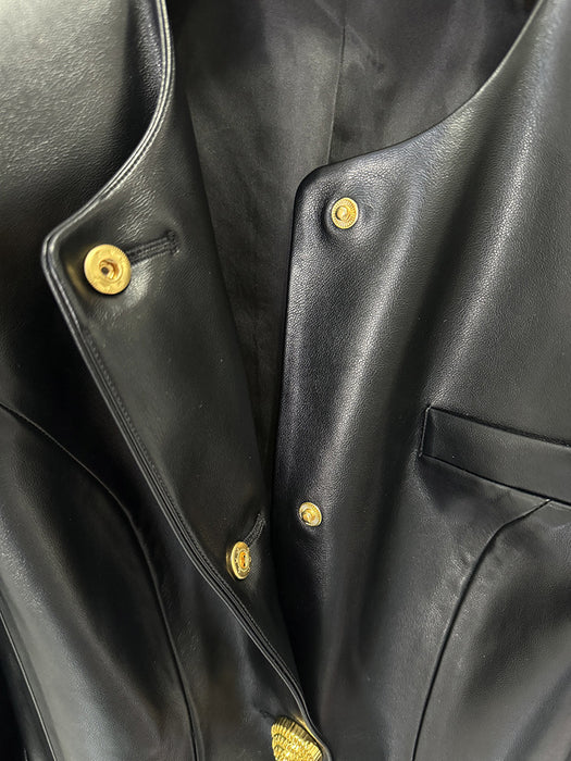 Close-up of a black leather jacket with gold buttons