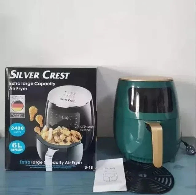 Green air fryer with packaging labeled 'Silver Crest' on a light blue surface.