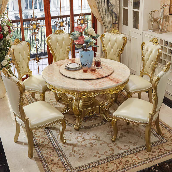 Elegant dining room with a marble table and gold-framed chairs.