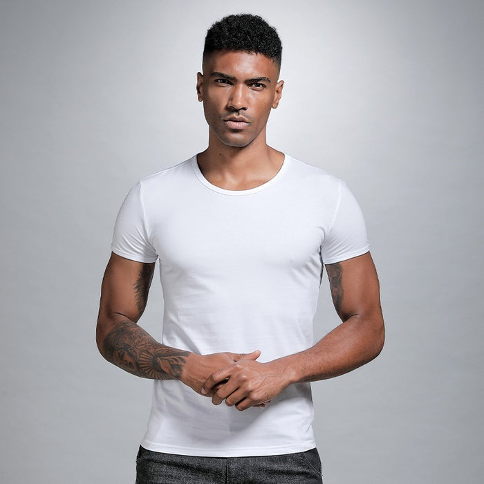 Man wearing a white t-shirt against a gray background