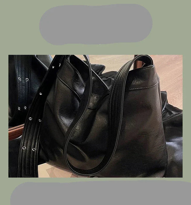 Black leather handbag with a strap on a textured surface